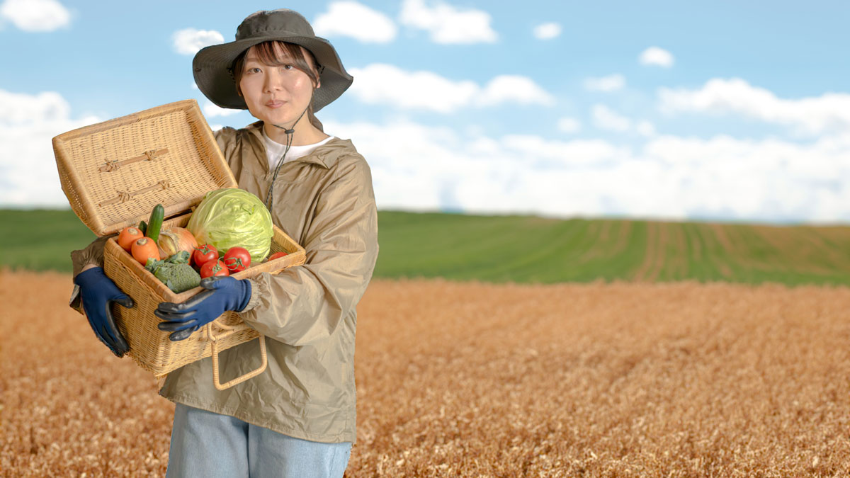 収穫野菜をバスケットに入れて持つ女性